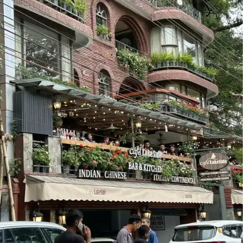 Front exterior of Cafe Lakeside in Nainital featuring balcony seating, hanging plants, and restaurant signage.