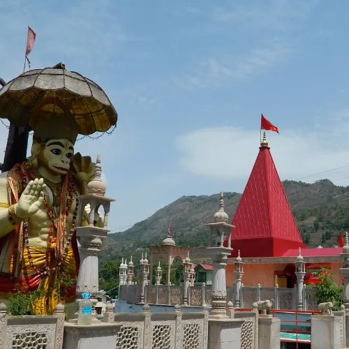 Large Hanuman statue and Hanuman Mandir in Nainital with mountain scenery in the background.