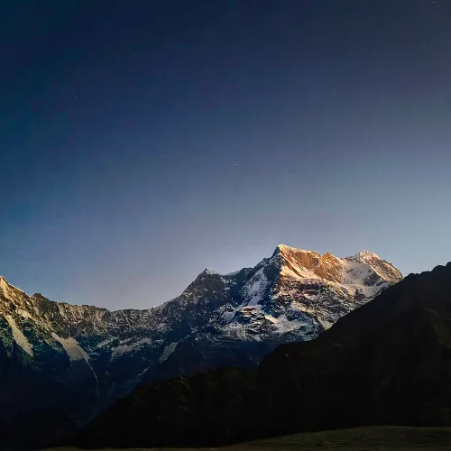 Scenic view of snow-covered Himalayan peaks near Madmaheshwar Temple during early morning light.