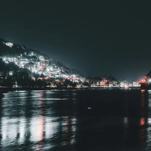 Night view of Nainital city with shimmering lights reflecting on Naini Lake